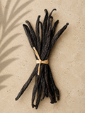 10 luna vanilla gourmet bourbon beans tied with raffia string on a beige background