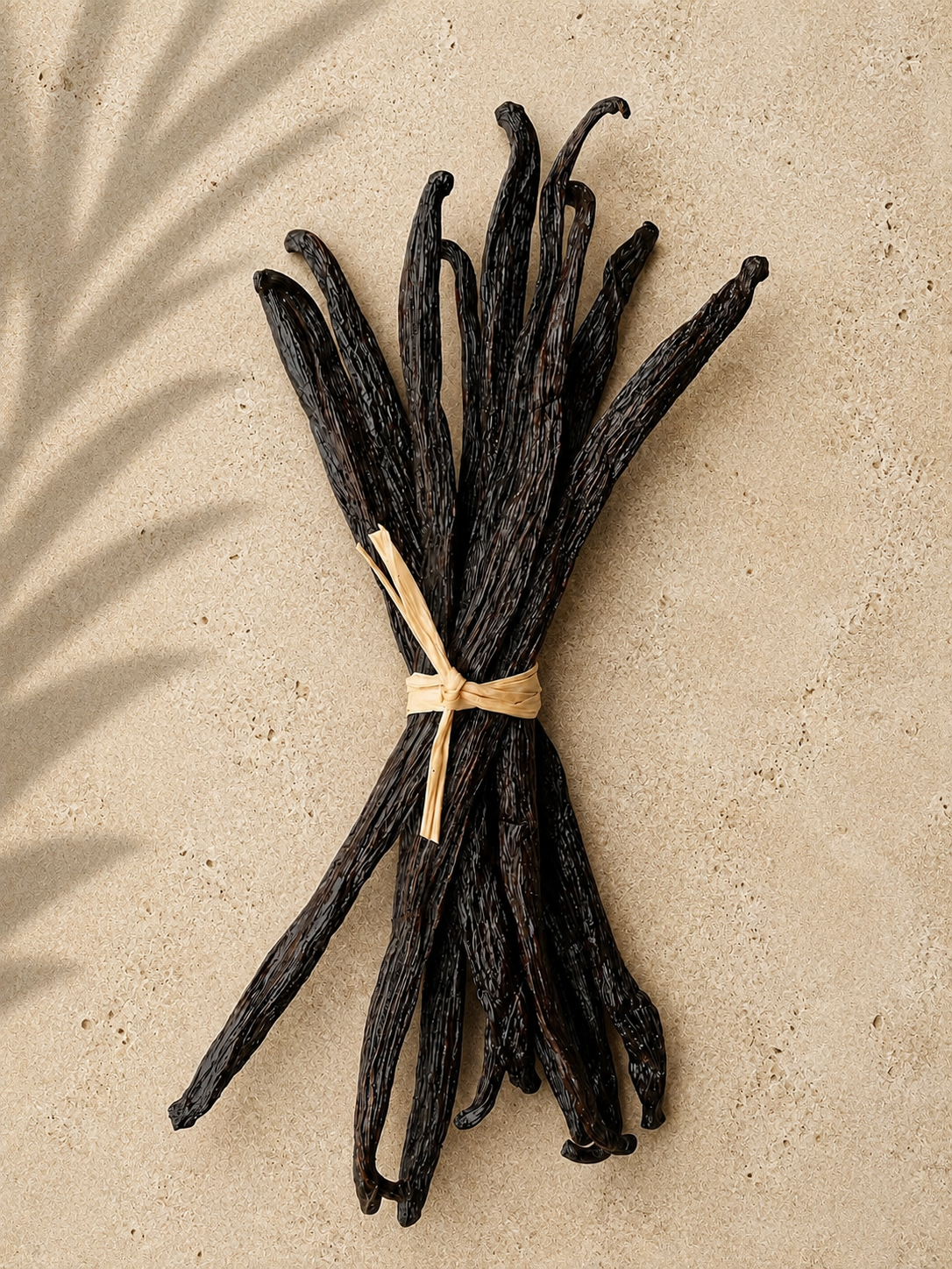 10 luna vanilla gourmet bourbon beans tied with raffia string on a beige background