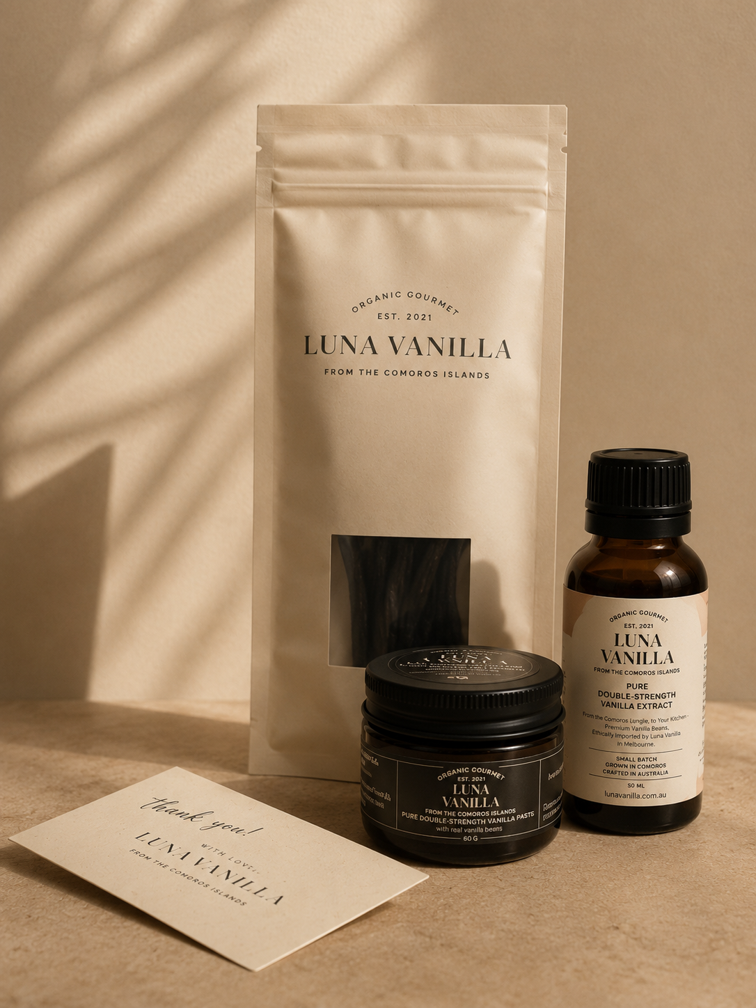 Luna Vanilla Discovery Bundle products including a 5 whole bean pack, 50ml bottle of vanilla extract, 50g vanilla paste jar, and thank you card on a beige background