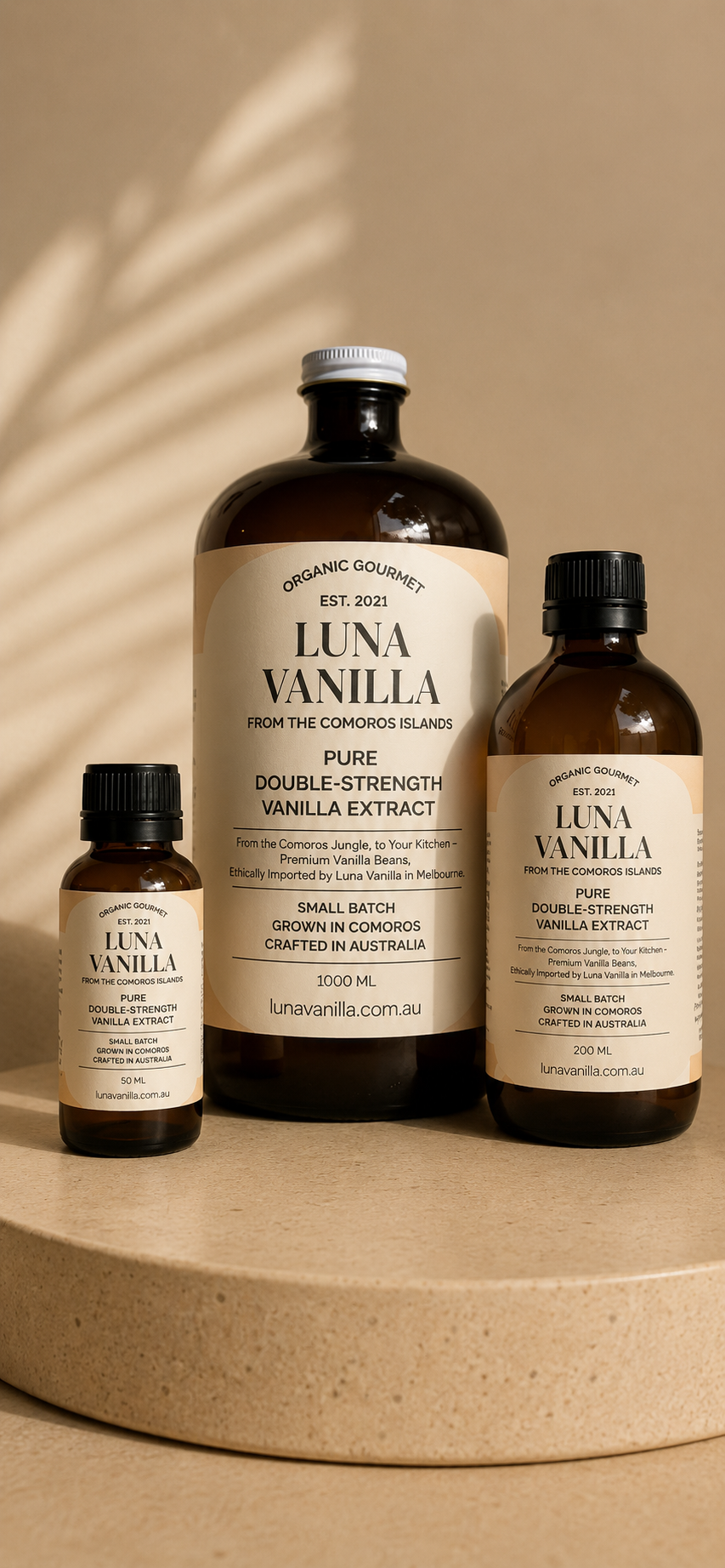 Luna Vanilla extract bottles of 50ml, 200ml and 1 litre on a beige surface with a neutral background